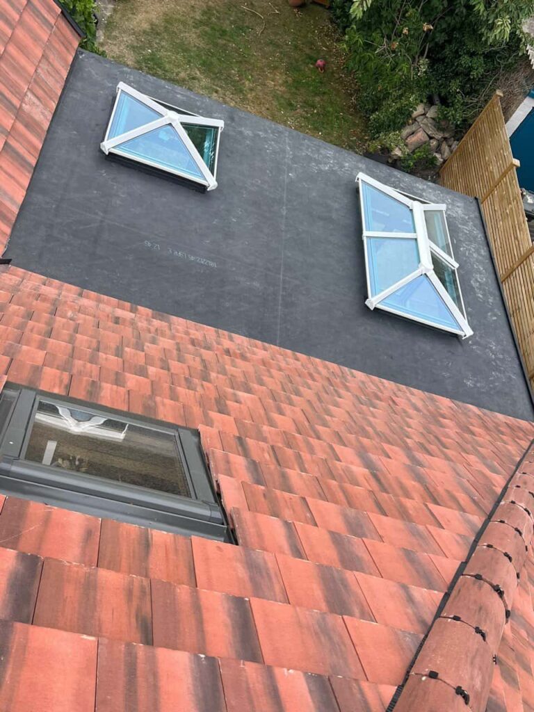 This is a photo taken from the roof ridge looking down a tiled pitched roof on to a flat roof. Works carried out by LS Roofing Earley